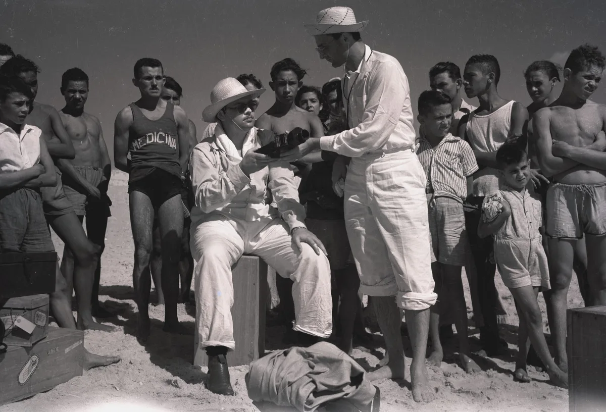 Equipe de filmagem e moradores na praia